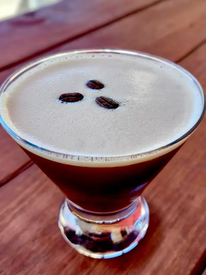 An espresso martini topped with coffee beans